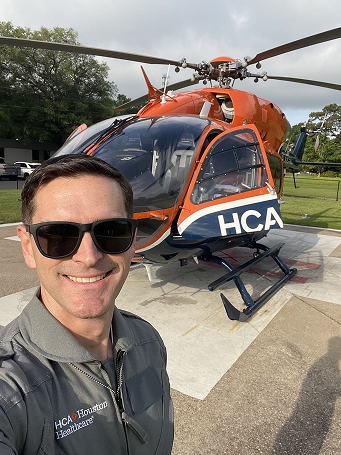 John Wolfe Chief Operating Officer stands near helicopter