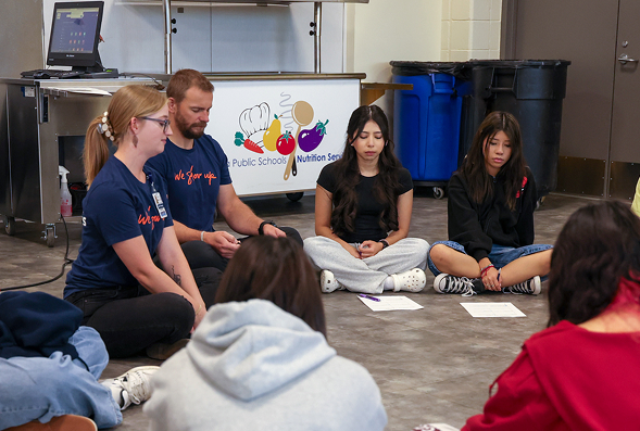 Aurora student mental health event, people sitting in a circle at a meditation station.